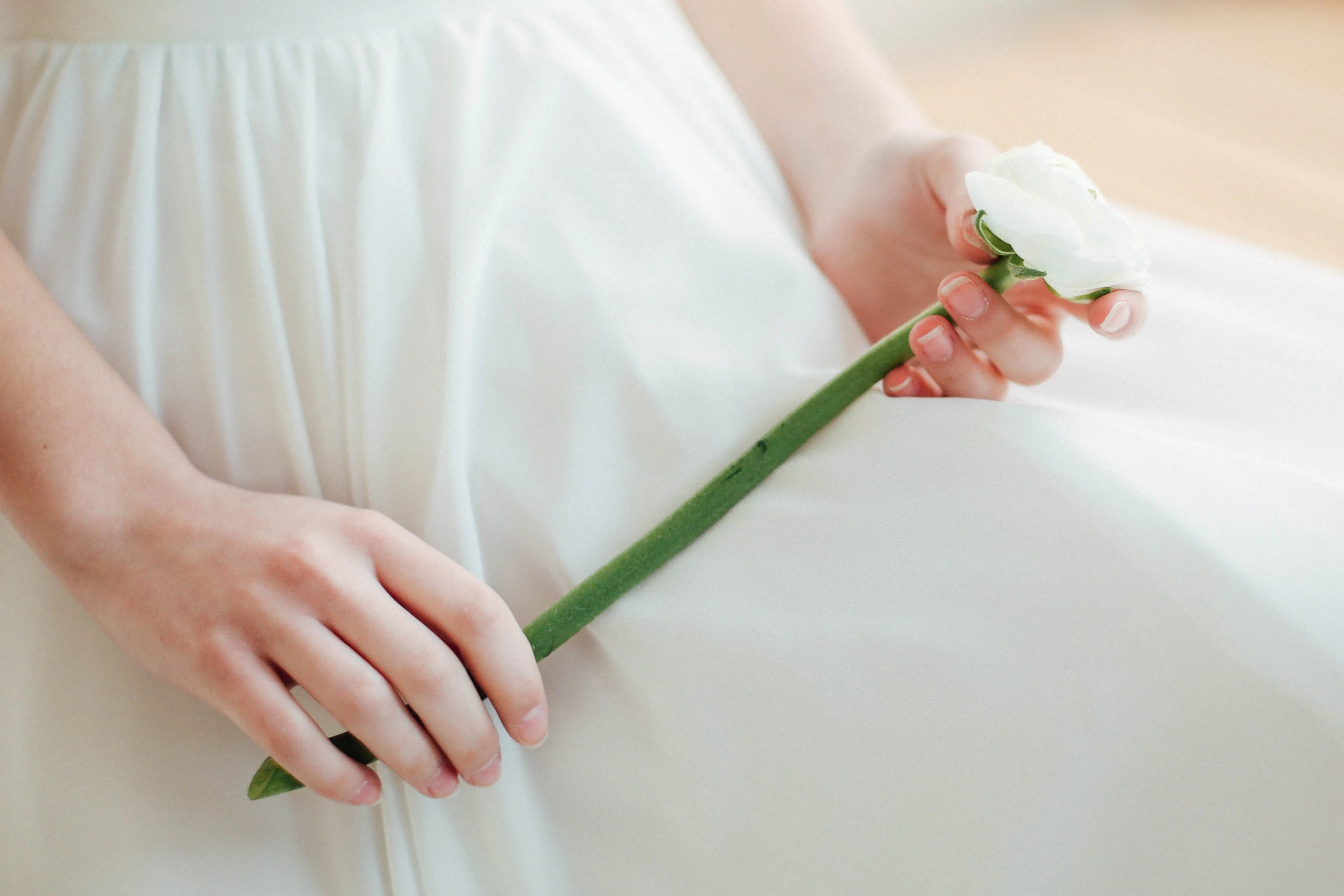 Bride holding a single-stem flower